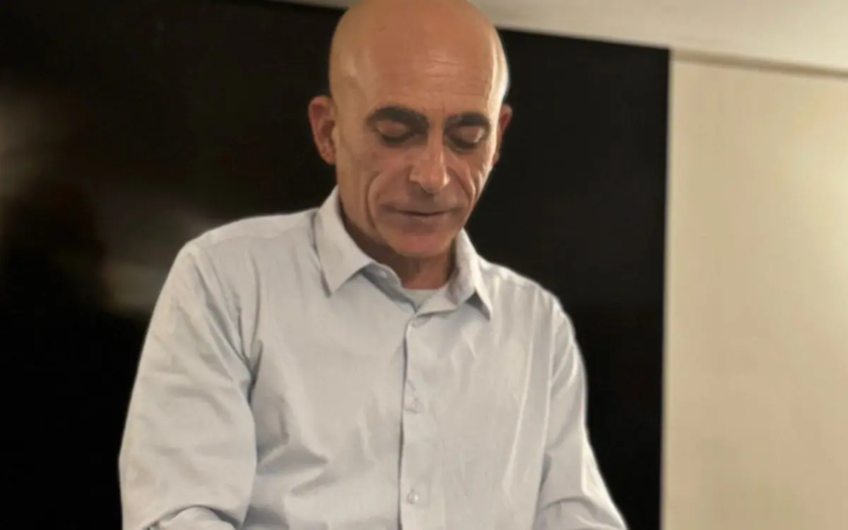 מנחה פותח בקבוק יין ליד שולחן הטעימה